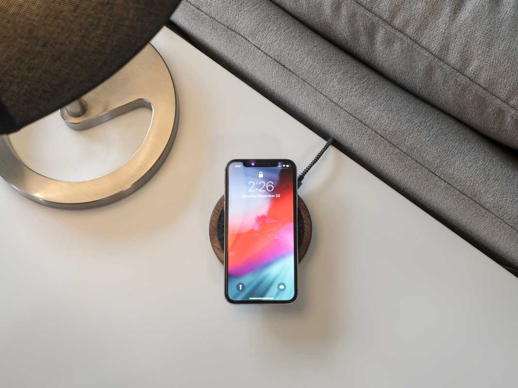 a phone laying on a qi charging pad in a living room.