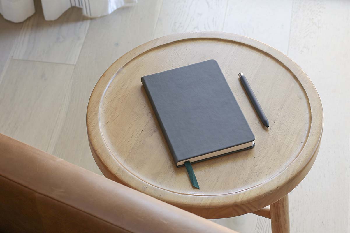 a keepbook on a stool next to a pen.