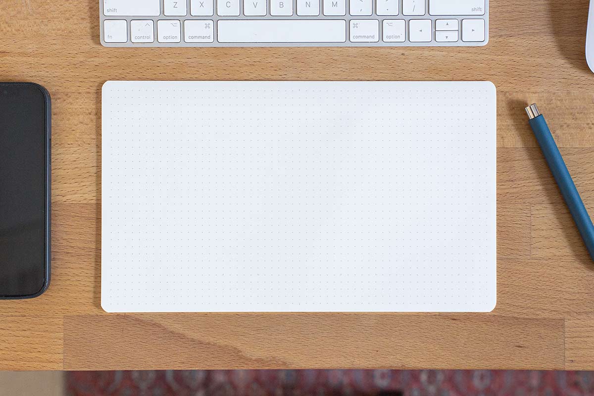 A Panopad on a desk under a keyboard.