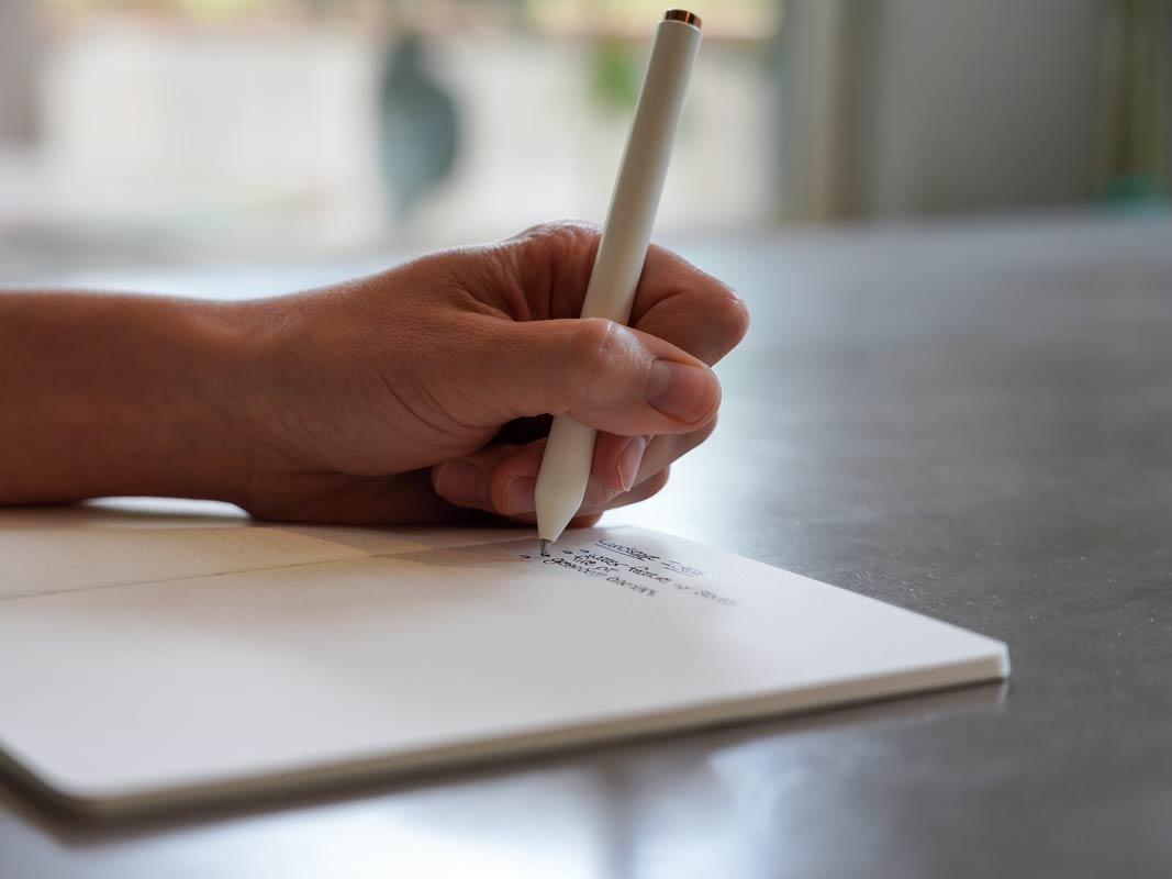 A Totebook being written in on a concrete table.