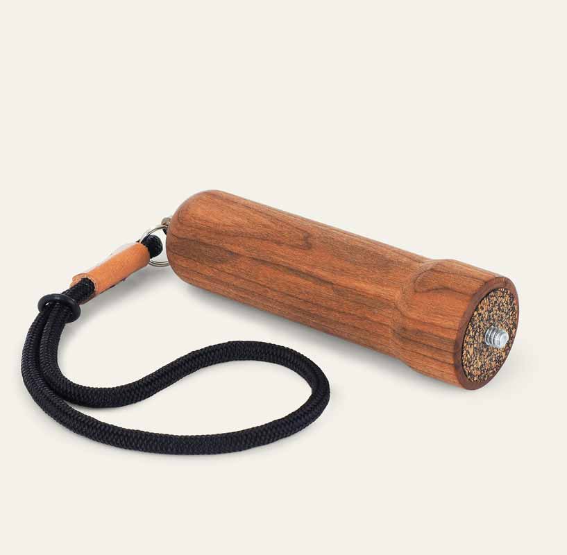 the cherry wood handle with cork pad and nylon wrist strap laying on a surface.