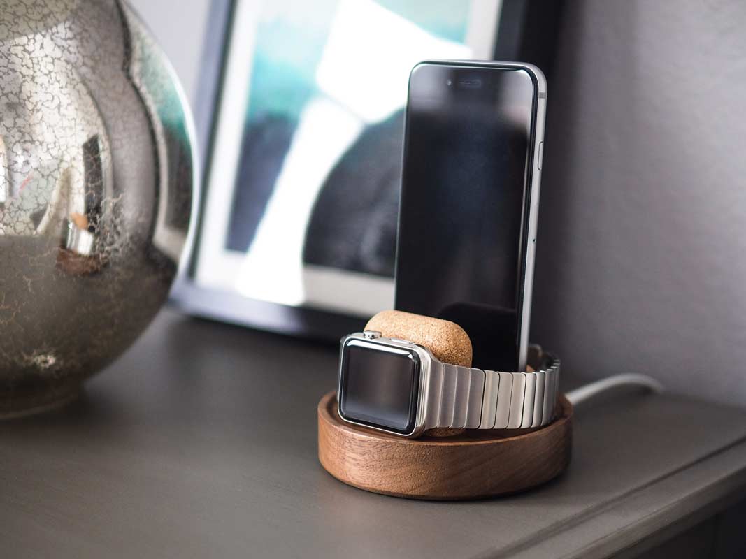 an Apple Watch and phone changing standing up on one dock.