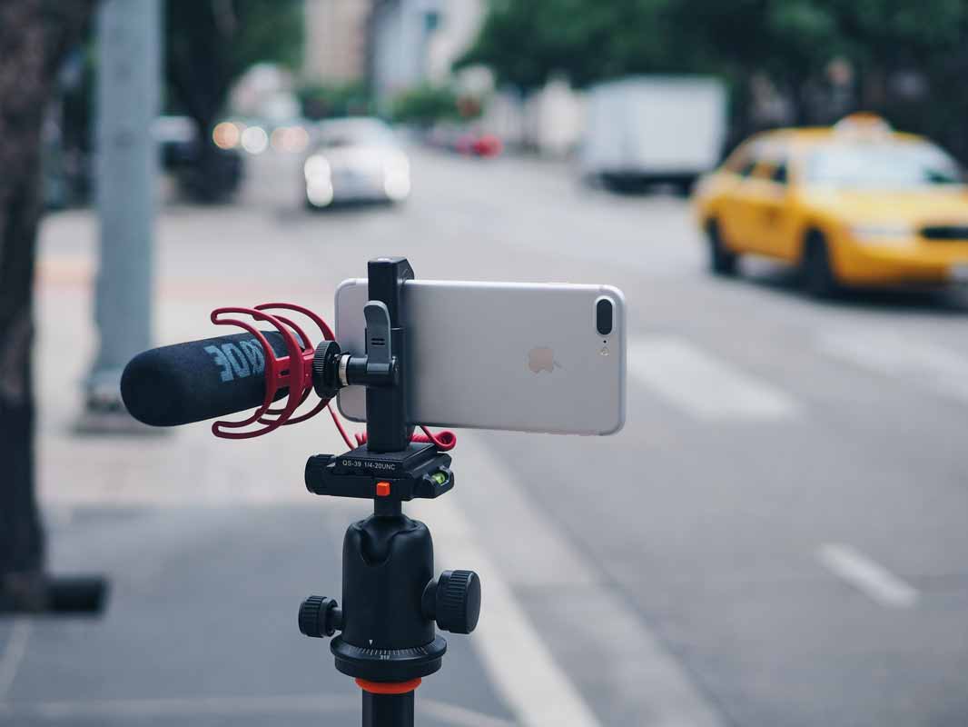 the glif on a tripod with a shotgun mic attached near a busy street.