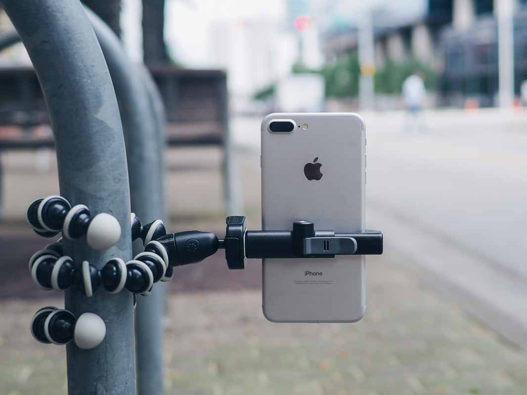 the glif attached to a vertical pole via a tripod holding a phone vertically.