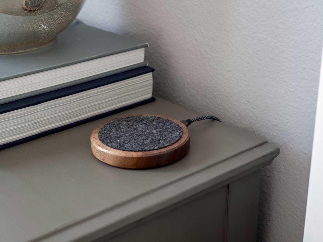 the qi-only material dock sitting on a night stand.